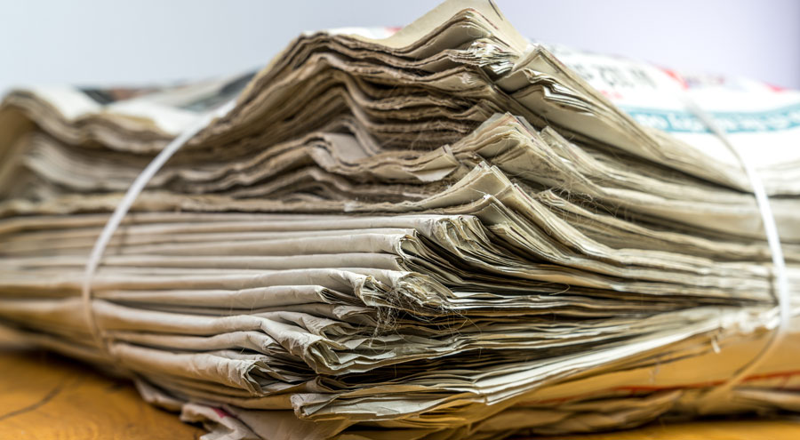 Tied pack of paper newspapers on wooden table