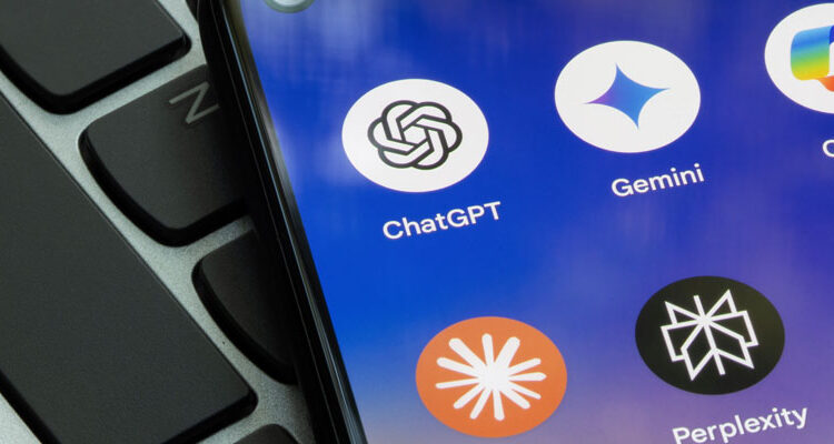 Close-up of a smartphone showing icons for ChatGPT, Gemini, Copilot, and Perplexity AI apps next to a laptop keyboard, representing modern AI search engines and digital assistants.