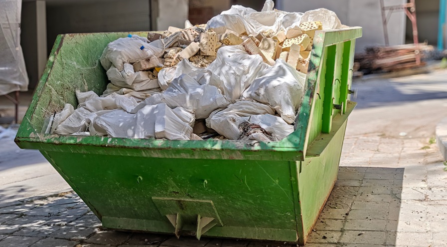 Industrial Dumpster Full of Construction Debris and Rubble on Urban Street. Building Renovation Waste Management and Cleanup Concept